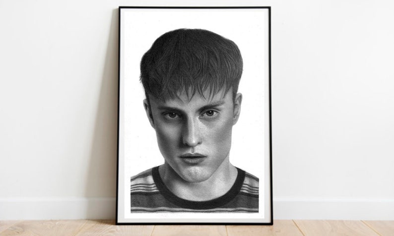 May include: A black and white pencil drawing of a person with short, dark hair. The person is looking directly at the viewer with a serious expression. They are wearing a striped shirt.