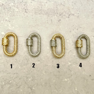 May include: Four oval-shaped clasps with a pave diamond design. The clasps are in gold, silver, gold, and silver finishes. The clasps are numbered 1 through 4.