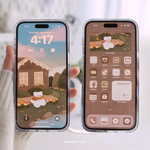May include: Two smartphones in clear cases, each displaying a custom home screen. One shows a house illustration with a bear, the other a bear in a field. The time is 4:17. The screens have a brown and beige color scheme.