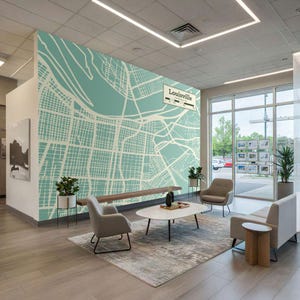 May include: An interior space featuring a large wall mural of a map of Louisville, Kentucky, in a teal and cream color scheme. The room includes seating, a coffee table, and potted plants, creating a modern and inviting atmosphere.