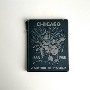 May include: A vintage book cover with the word "CHICAGO" in silver lettering. The cover features illustrations of a Native American chief and a woman, with the years 1833 and 1933, and the text "A Century of Progress".