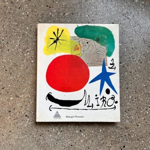 May include: A book cover featuring abstract art with a red circle, blue star, and green shapes on a white background. The title "Miro" is written in black script, with the author's name, Margit Rowell, below.