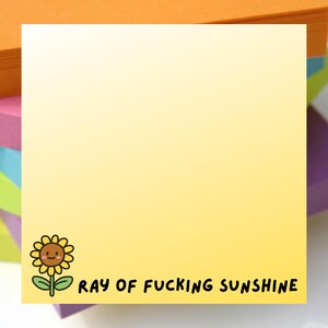 May include: A yellow sticky note with a cartoon sunflower illustration and the text "RAY OF FUCKING SUNSHINE" in black. The note is part of a stack of colorful sticky notes.