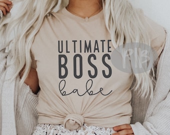 May include: A beige t-shirt with the text "ULTIMATE BOSS babe" printed in black.