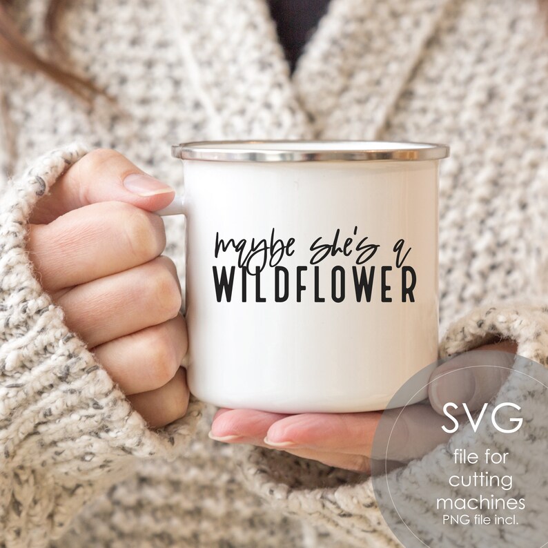 May include: White enamel mug with a black inscription that reads "maybe she's a wildflower".