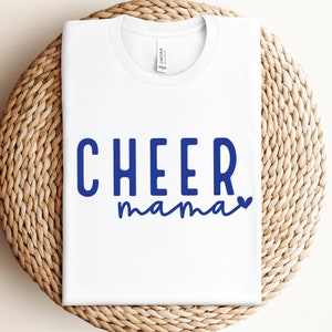 May include: White t-shirt with the text "CHEER mama" in blue lettering with a small heart after "mama".