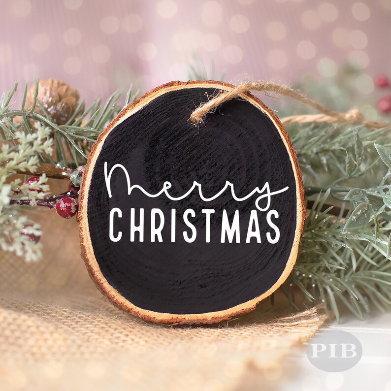 May include: A black wood slice ornament with the text "Merry Christmas" in white lettering.