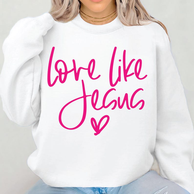 May include: White sweatshirt with a pink graphic that says "love like Jesus" with a pink heart.