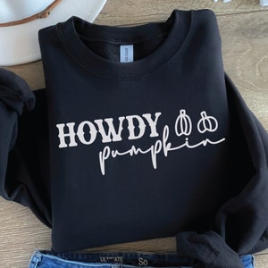 May include: Black sweatshirt with white text that reads "Howdy Pumpkin" with two pumpkin illustrations.