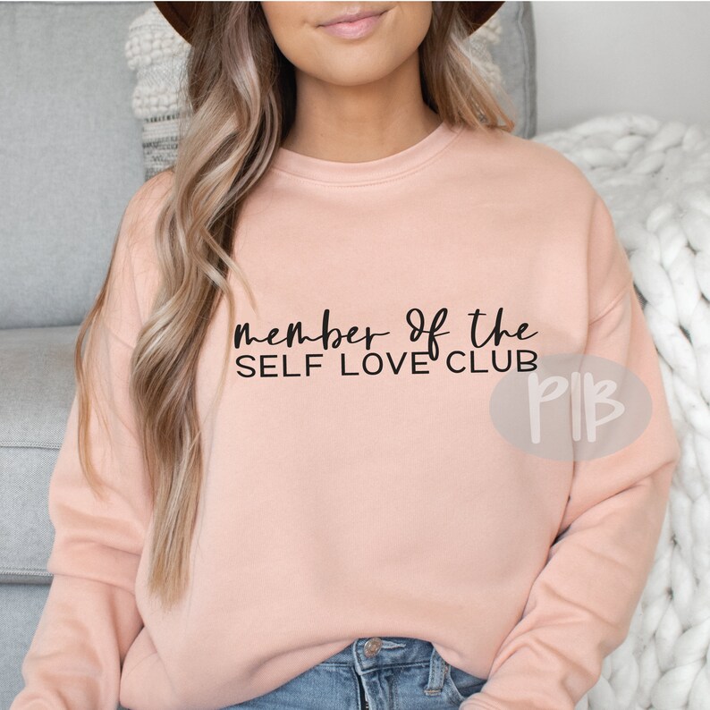 May include: A pink sweatshirt with the text "member of the self love club" in black lettering.