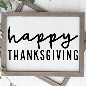 May include: A framed sign with the text "happy thanksgiving" in black script font on a white background.