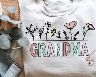 May include: A light grey sweatshirt with a graphic design of flowers and the word "GRANDMA" in pink, green and blue.