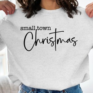 May include: A gray sweatshirt with the text "small town Christmas" in black lettering.