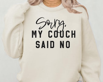 May include: A cream colored sweatshirt with the text "Sorry, my couch said no" in black.