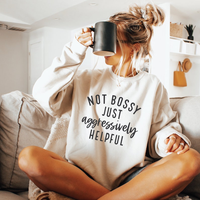 May include: A white sweatshirt with the text "NOT BOSSY JUST aggressively HELPFUL" printed on the front.