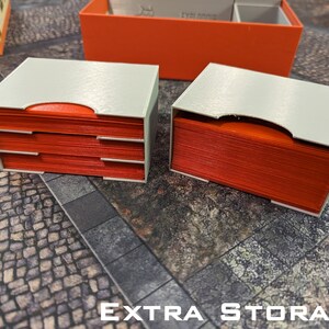 May include: Two white storage boxes with red card inserts. The boxes are labelled "EXTRA STORAGE".