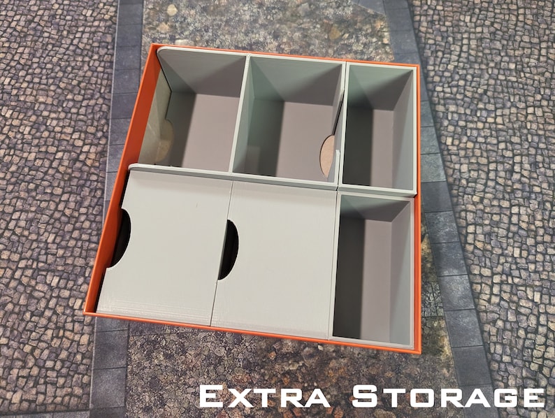 May include: An orange and grey cardboard box with dividers for organising small items. The box has the words "EXTRA STORAGE" printed on the bottom.