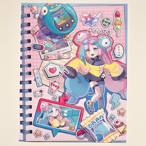 May include: A spiral-bound notebook with a pink grid pattern featuring anime-style illustrations and stickers. The cover includes a character with blue and pink hair, a digital pet, and a candy wrapper. The notebook has a blue spiral binding.