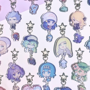 Puede incluir: Una colección de llaveros coloridos de personajes de estilo anime. Cada llavero presenta un diseño de personaje diferente, con un cierre en forma de estrella y un pequeño dije. Los llaveros están hechos de acrílico transparente y son adecuados para los fanáticos del anime.