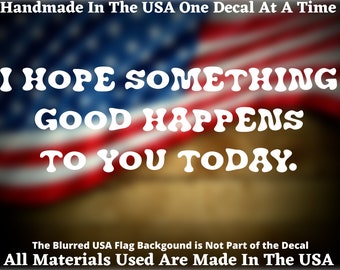 May include: White text on a blurred American flag background reads "I HOPE SOMETHING GOOD HAPPENS TO YOU TODAY." The text is in a bold, rounded font. The decal is handmade in the USA.