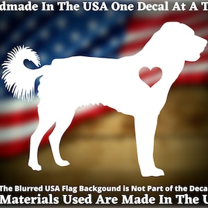 May include: White silhouette of a dog with a red heart on its chest, against a blurred American flag background. The text "Handmade in the USA One Decal at a Time" and "All Materials Used Are Made In The USA" are at the top and bottom of the image.