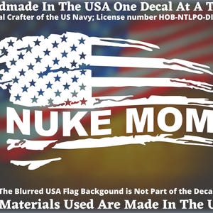 May include: A white decal featuring a stylized American flag design with the text "NUKE MOM" in bold letters. The decal is handmade in the USA and is an official crafter of the US Navy. The text "All Materials Used Are Made In The USA" is also included.