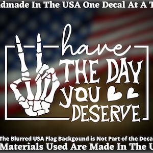May include: White decal featuring a skeleton hand making a peace sign, with the words "have THE DAY YOU DESERVE" in a stylized font. The text "Handmade In The USA" and "All Materials Used Are Made In The USA" are also included.