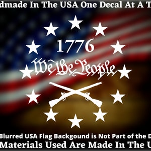 May include: White decal featuring the text "1776" and "We the People" surrounded by stars, with crossed rifles below. The text "Handmade In The USA One Decal At A Time" is at the top. The text "The Blurred USA Flag Backgound is Not Part of the Decal All Materials Used Are Made In The USA" is at the bottom.