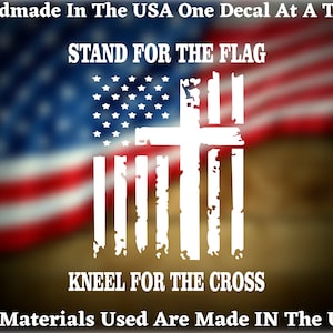 May include: White vinyl decal with a distressed American flag design and a cross superimposed over it. The text "STAND FOR THE FLAG" is above the design and "KNEEL FOR THE CROSS" is below. The text "Handmade In The USA One Decal At A Time" is at the top of the image and "All Materials Used Are Made IN The USA" is at the bottom.