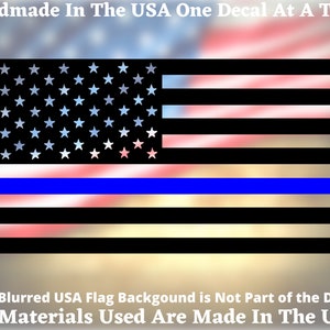 May include: Black and white American flag decal with a blue stripe across the middle. The text "Handmade In The USA One Decal At A Time" and "All Materials Used Are Made In The USA" are at the top and bottom of the image.