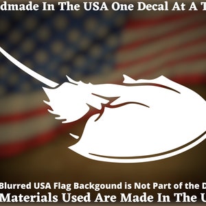 May include: White vinyl decal of a horseshoe crab silhouette against a blurred American flag background. The decal reads "Handmade in the USA One Decal at a Time. All Materials Used Are Made in the USA."