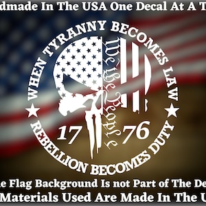 May include: White vinyl decal featuring a skull and crossbones design. The decal includes the text "When Tyranny Becomes Law Rebellion Becomes Duty" and the numbers "17 76". The decal is displayed against a blurred American flag background.