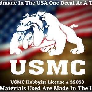May include: White vinyl decal of a bulldog with the text "USMC" and the words "USMC Hobbyist License # 22058" and "All Materials Used Are Made In The USA".