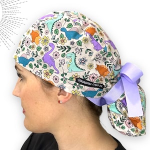 恐竜柄の花柄ポニーテールスクラブキャップ（ロングヘア用）。サテン裏地付き（オプション）。女性用恐竜サージカルスクラブハット。ポニーテールポーチ付きスクラブキャップ。