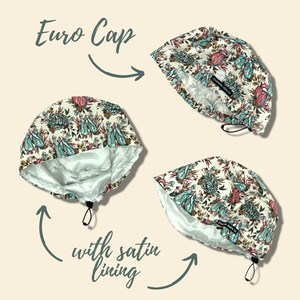 Puede incluir: Gorro Euro con un estampado floral en verde azulado, rosa y crema. El gorro tiene un forro de sat&eacute;n y un cierre de cord&oacute;n. El texto dice "Euro Cap" y "with satin lining".