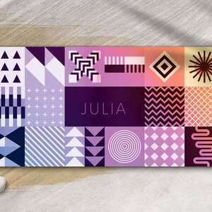 May include: A colorful geometric pattern card with the name "JULIA" in the center. The card features a variety of shapes and colors, including triangles, squares, circles, and stripes.