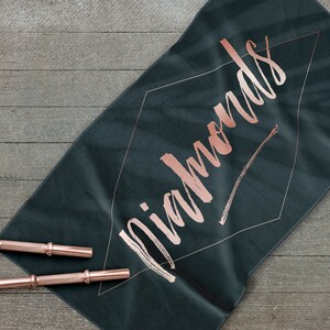 May include: A dark green yoga mat with the word "Diamonds" written in rose gold lettering.