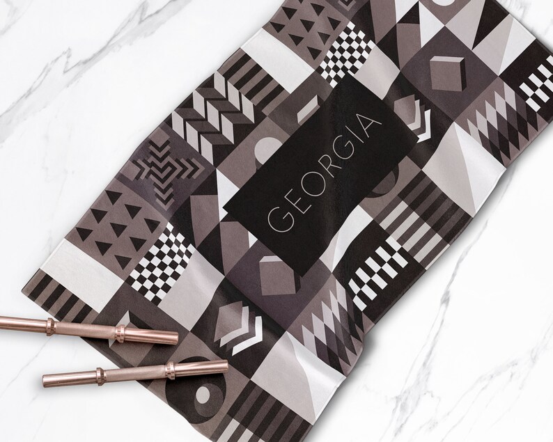 May include: A black and white geometric patterned towel with the word "GEORGIA" in white text on a black background.