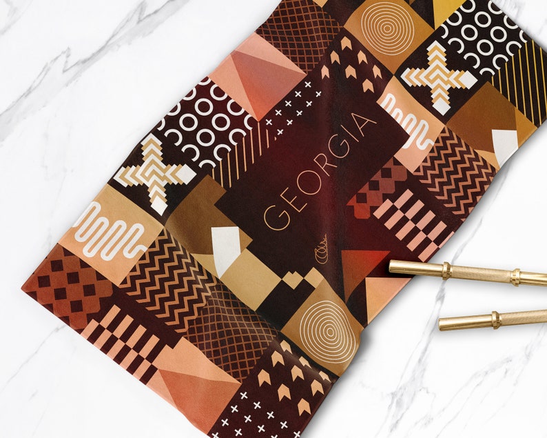 May include: A brown and beige geometric patterned fabric with the word "GEORGIA" in white text.