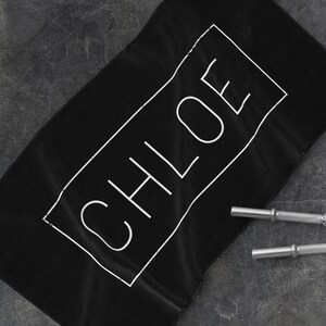 K&ouml;nnte beinhalten: Schwarzes Sporttuch mit dem Namen CHLOE in wei&szlig; in einem wei&szlig;en Rechteck gedruckt.