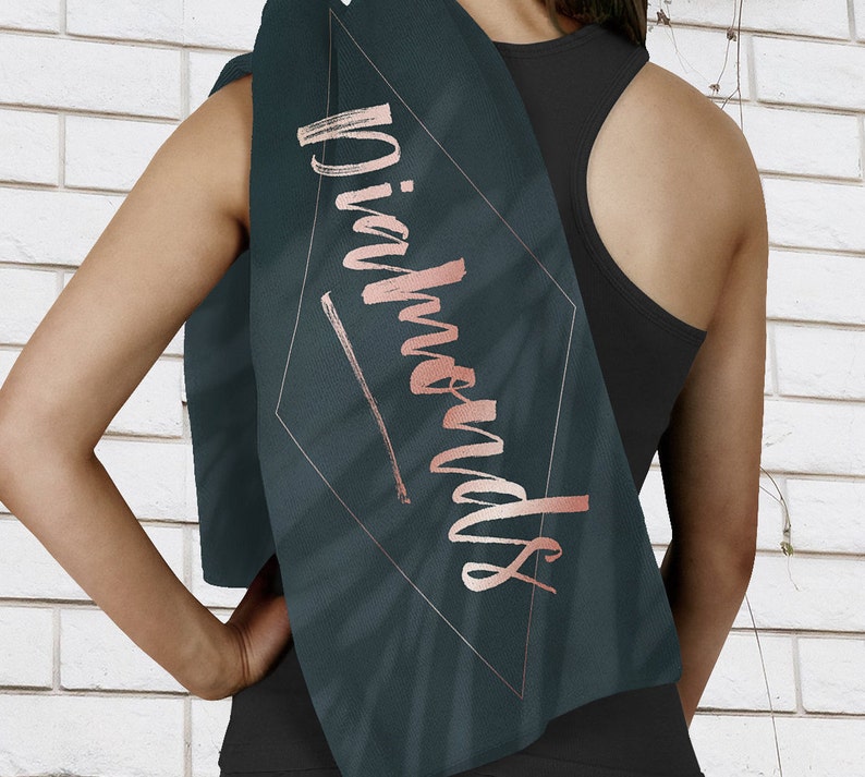 May include: A dark green yoga towel with a diamond-shaped design and the word "Diamonds" written in rose gold lettering.