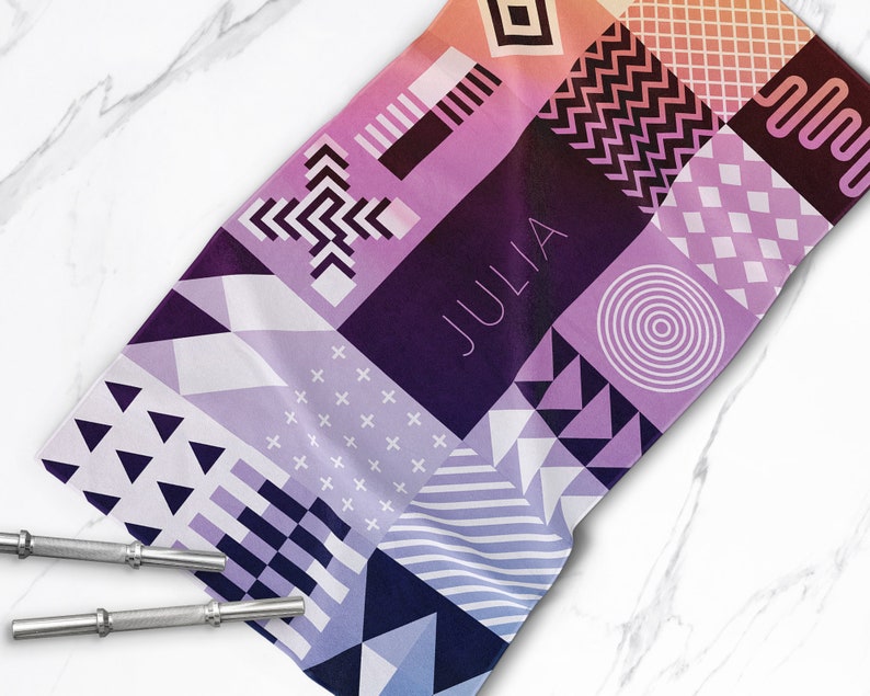 May include: A colorful geometric patterned towel with the name "JULIA" printed in white on a purple background.
