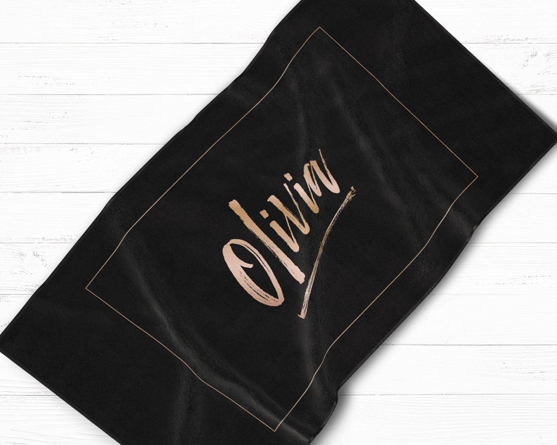 May include: Black beach towel with a gold frame and the name "Olivia" written in gold script.