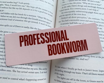 May include: A pink and white bookmark with the text "PROFESSIONAL BOOKWORM" in red lettering.