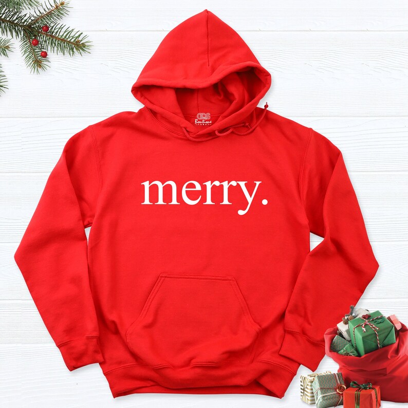 May include: Red hooded sweatshirt with the word "merry" printed in white on the front.