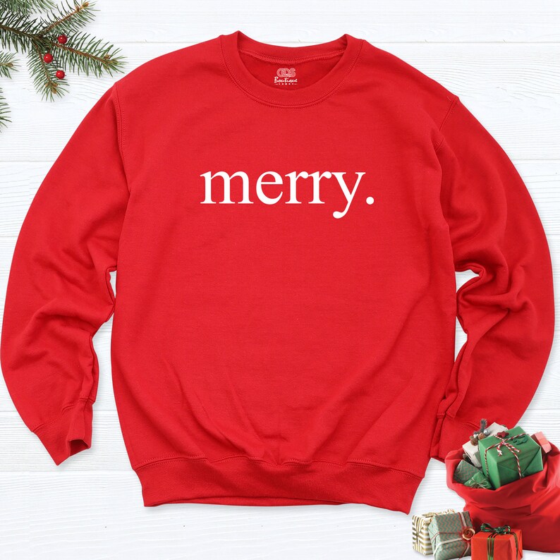 May include: Red Christmas sweatshirt with the word "merry" printed in white on the front.