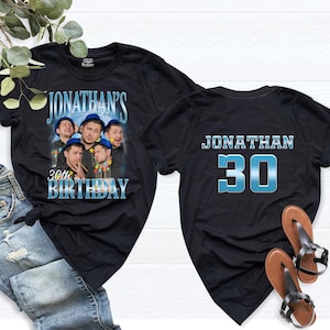 May include: Two black t-shirts. The front features a graphic of a man wearing a blue hat, repeated four times, with the text JONATHAN'S 30TH BIRTHDAY. The back features the text JONATHAN and the number 30 in a blue metallic font style.