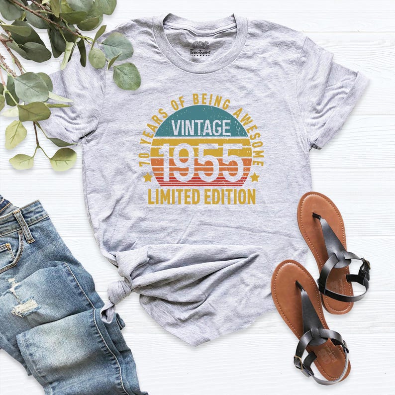 Op de afbeelding: Grijs T-shirt met een vintage-stijl grafische afbeelding met de tekst "70 Years of Being Awesome Vintage 1955 Limited Edition".