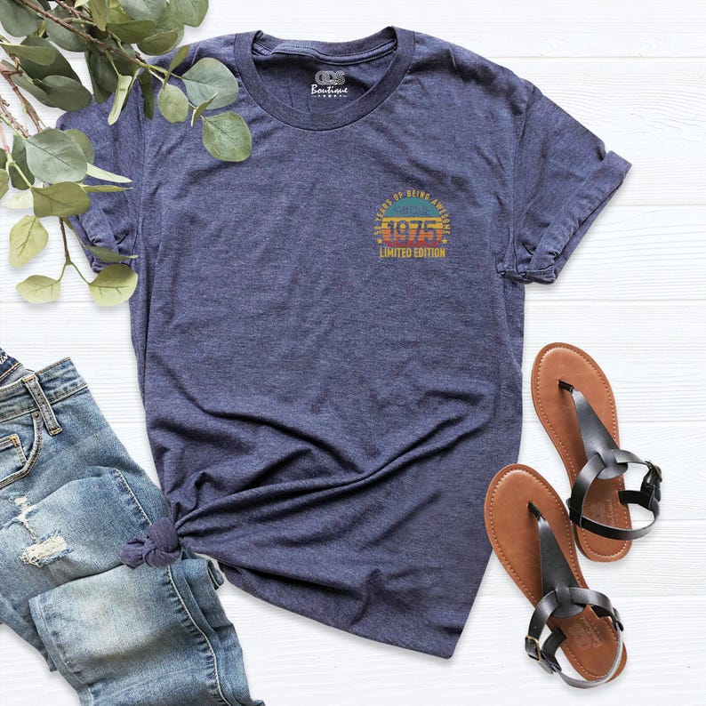 May include: A navy blue t-shirt with a vintage-style graphic that says "Years of Being Awesome 1975 Limited Edition".
