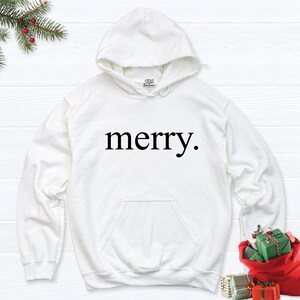 May include: White hooded sweatshirt with the word "merry." printed in black on the front.